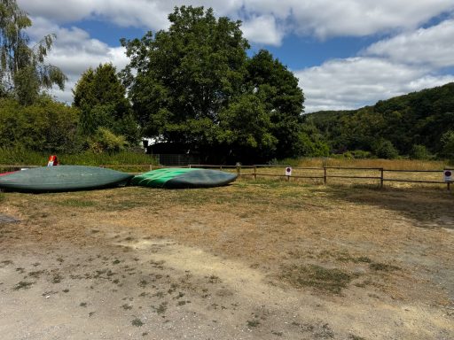 Bootsablage Aumenau auf der Wiese vor dem Holzzaun